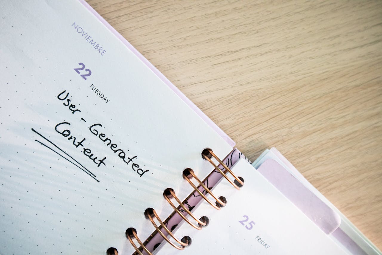 Open planner showing a date with handwritten notes on a wooden desk.